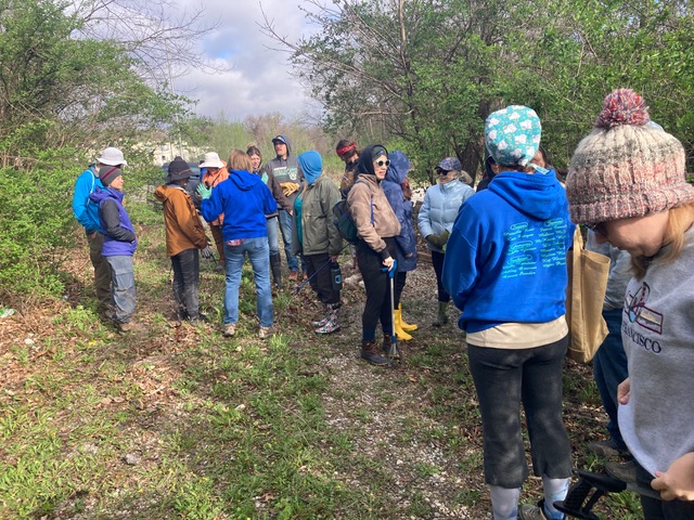 Cheryl Bolton carries her heavy bag of trash out of the creek.